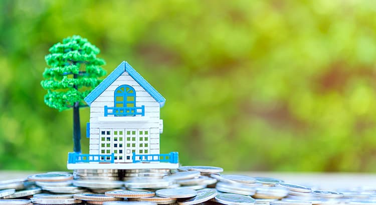 Close-Up Of Model house on coins stacked. Property investment and house mortgage financial concept.